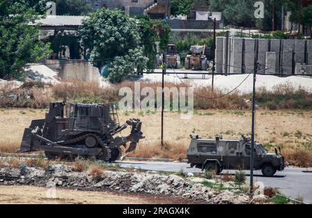 Dschenin, Palästina. 03. Juli 2023. Ein israelischer militärischer Bulldozer trifft im Flüchtlingslager Dschenin während eines Überfalls auf das Lager in der Nähe der Stadt Dschenin, nördlich des besetzten Westjordanlands, ein. Ein Angriff der israelischen Armee auf Dschenin, der mit mehreren Luftangriffen begann, gefolgt von einem Bodenangriff auf mehr als 100 gepanzerte Fahrzeuge. 9 Palästinenser wurden bei diesem Angriff getötet und Dutzende schwer verletzt. Kredit: SOPA Images Limited/Alamy Live News Stockfoto