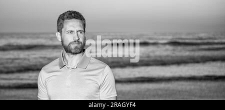 Mann Gesicht Porträt, Banner mit Kopierraum. Charismatischer Mann mit Bart in Sonnenuntergang über dem Meer. Unrasiert Kerl am Morgen Strand. Stockfoto