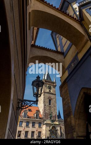 Das gotische Rathaus aus aus dem 14. Jahrhundert, bekannt für seinen Aussichtsturm und die komplizierte astronomische Uhr, ragt durch die Bögen der Prager Innenstadt. Stockfoto