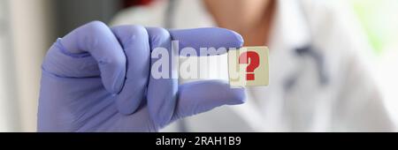 Ärztin Hand in Handschuh mit Fragezeichen Stockfoto