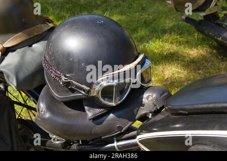 Helm und Schutzbrille auf einem alten Motorrad Stockfoto