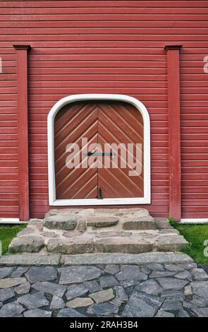 Geschlossener Eingang an rot bemalten Holzwänden im Freien Stockfoto