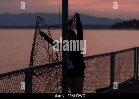 Seattle, USA. 3. Juli 2023. Krabbenfischer und Touristen kommen zusammen, um den Sonnenuntergang in der Elliott Bay zu beobachten, während Seattles Luftqualität deutlich sinkt, während vor den großen Feierlichkeiten am 4. Juli der Rauch des Klimaschutzes in den Puget Sound eindringt. Die PNW wird weiterhin jährlich von klimabezogenem Rauch heimgesucht. James Anderson/Alamy Live News Stockfoto