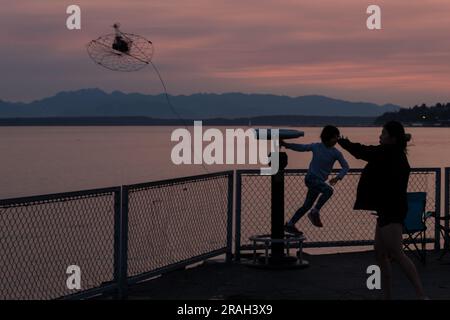 Seattle, USA. 3. Juli 2023. Krabbenfischer und Touristen kommen zusammen, um den Sonnenuntergang in der Elliott Bay zu beobachten, während Seattles Luftqualität deutlich sinkt, während vor den großen Feierlichkeiten am 4. Juli der Rauch des Klimaschutzes in den Puget Sound eindringt. Die PNW wird weiterhin jährlich von klimabezogenem Rauch heimgesucht. James Anderson/Alamy Live News Stockfoto