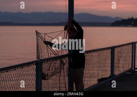 Seattle, USA. 3. Juli 2023. Krabbenfischer und Touristen kommen zusammen, um den Sonnenuntergang in der Elliott Bay zu beobachten, während Seattles Luftqualität deutlich sinkt, während vor den großen Feierlichkeiten am 4. Juli der Rauch des Klimaschutzes in den Puget Sound eindringt. Die PNW wird weiterhin jährlich von klimabezogenem Rauch heimgesucht. James Anderson/Alamy Live News Stockfoto