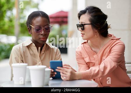 Elegante Frauen diskutieren über Modeeinflussfaktoren und Trends Stockfoto