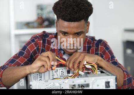 Computeringenieur, der an einer defekten Konsole in seinem Büro arbeitet Stockfoto