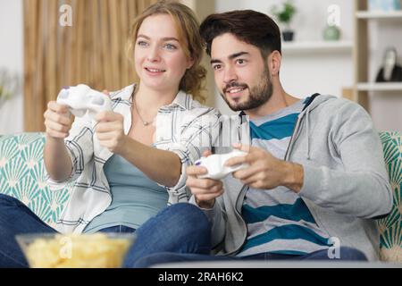 Mann und Frau spielen Videospiele mit Joysticks Stockfoto