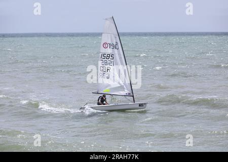 Ein Mann, der in einem kleinen Boot auf einer unruhigen See segelt. Stockfoto