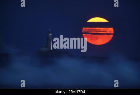 Der Full Buck-Supermond erhebt sich über dem St. Mary's Lighthouse in Whitley Bay an der Nordostküste Englands. Der Juli-Supermond erreicht seinen nächstgelegenen Punkt zur Erde mit 224.895 Meilen (361.934km km) - etwa 13.959 Meilen (22.466km km) näher als üblich. Es erscheint 5,8 Prozent größer und 12,8 Prozent heller als ein normaler Vollmond. Foto: Montag, 3. Juli 2023. Stockfoto