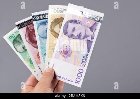 Altes norwegisches Geld - Krone in der Hand auf grauem Hintergrund Stockfoto