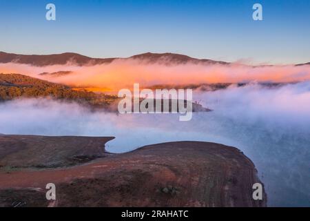 Luftaufnahme des Morgennebels auf der Wasseroberfläche des Eildon-Sees und der umliegenden Berge in Victoria, Australien Stockfoto