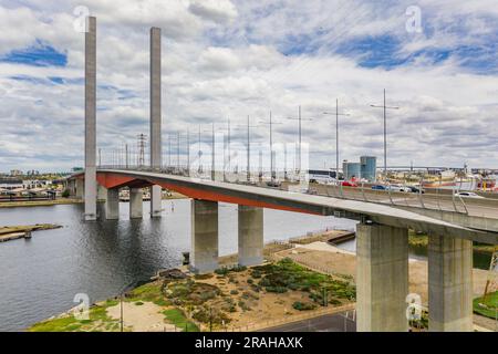 Blick aus der Vogelperspektive auf die lange Brücke mit zwei Türmen, die einen breiten Fluss in den Docklands in Melbourne in Victoria, Australien, überspannen Stockfoto