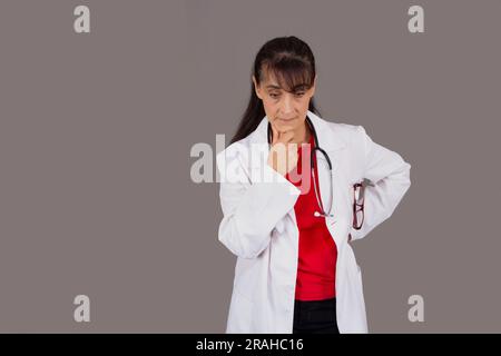 Ärztin mit durchdachtem Gesichtsausdruck isoliert vom Hintergrund Stockfoto