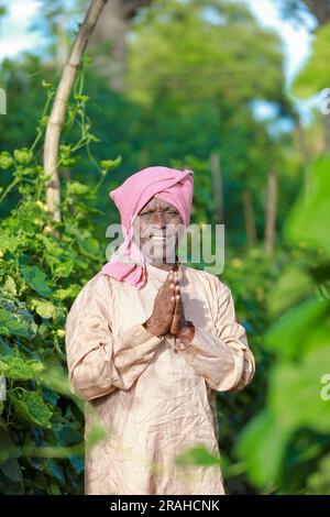 Indische Landwirtschaft, glücklicher indischer Bauer, der dich begrüßt, indischer Bauer, der namensvolle Hände zeigt Stockfoto