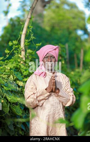 Indische Landwirtschaft, glücklicher indischer Bauer, der dich begrüßt, indischer Bauer, der namensvolle Hände zeigt Stockfoto