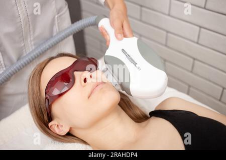 Kosmetikerin führt Photoepilierung, Hautverjüngung, Entfernung von Sommersprossen und Akne, Anti-Aging-Verfahren durch. Kunde. Stockfoto