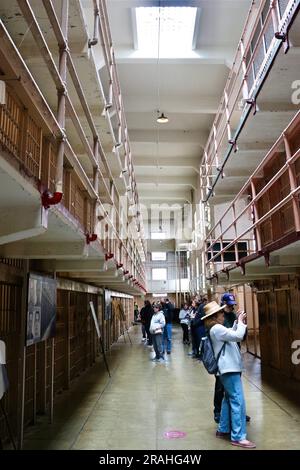 Touristen im Bundesgefängnis Alcatraz blicken auf die Korridore mit Gefängniszellen Alcatraz Island San Francisco California USA Stockfoto