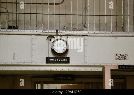 Uhr über dem Times Square Schild neben einem Metalldetektor am Eingang zum Speisesaal Alcatraz Gefängnis San Francisco Kalifornien USA Stockfoto