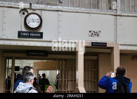 Uhr über dem Times Square Schild neben einem Metalldetektor am Eingang zum Speisesaal Alcatraz Gefängnis San Francisco Kalifornien USA Stockfoto
