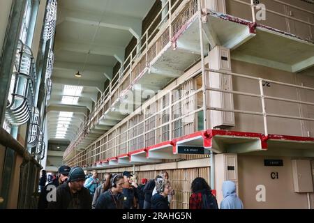 Touristen im Bundesgefängnis Alcatraz blicken auf die Korridore mit Gefängniszellen Alcatraz Island San Francisco California USA Stockfoto