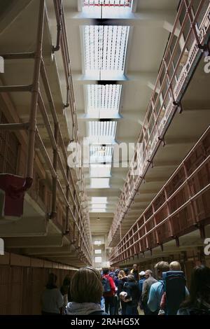 Touristen im Bundesgefängnis Alcatraz blicken auf die Korridore mit Gefängniszellen Alcatraz Island San Francisco California USA Stockfoto