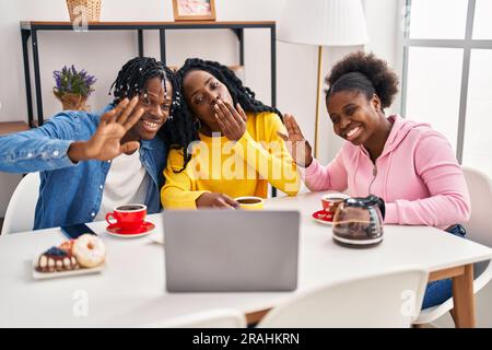 afroamerikanische Freunde frühstücken mit einem Laptop zu Hause Stockfoto
