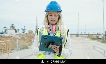 Junge blonde Architektin mit Touchpad auf der Straße Stockfoto