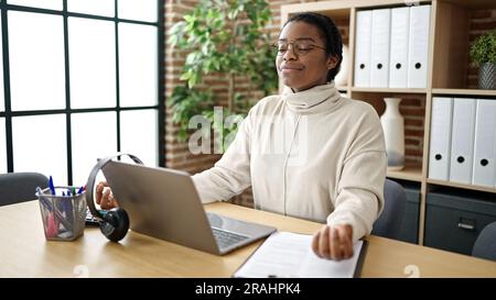 Eine afroamerikanische Geschäftsfrau, die Yoga-Übungen im Büro macht Stockfoto