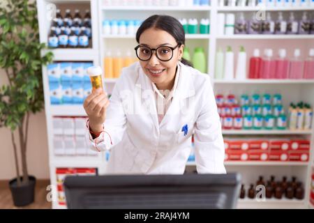 Junge arabische Apothekerin mit Computer-Pillen-Flasche in der Apotheke Stockfoto