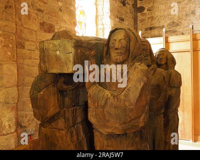 Licht leuchtet durch ein neues farbiges Buntglasfenster, das St. Cuthbert mit Gauner in der Priory Lindisfarne, Holy Island, Northumbria, England, Großbritannien darstellt Stockfoto