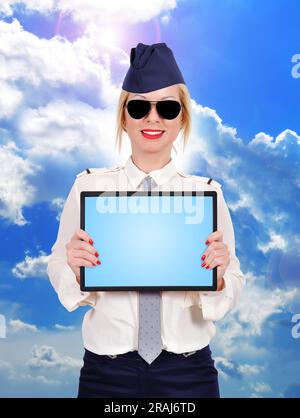 Flugbegleiter hält Touchpad auf Himmelshintergrund Stockfoto