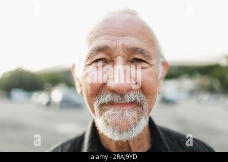 Glücklicher Seniorenmensch, der draußen vor der Kamera lächelt - Lebensstil älterer Menschen - Hauptfokus auf Nase Stockfoto