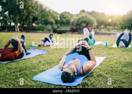 Seniorensportler, die während des Yoga-Workout-Kurses im Freien im Park City trainieren - Fitness und ein erholsamer Lebensstil für ältere Menschen Stockfoto