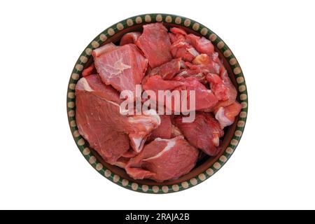 Fleischstücke auf einem rustikalen Gericht isoliert auf weißem Hintergrund. Rohes Rindfleisch zum Kochen. Draufsicht. Stockfoto