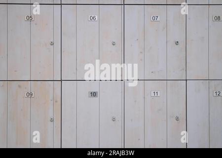 Braune Schließfächer aus Holz zur Aufbewahrung von Gegenständen im Geschäft. Schließfächer mit Zahlen und einer Nahaufnahme. Hochwertiges Foto Stockfoto