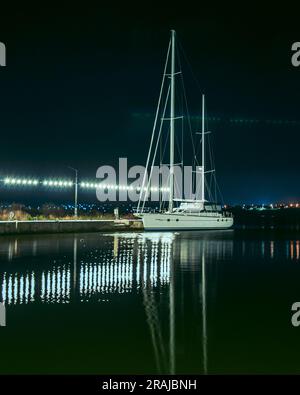 Eine weiße Yacht im Meer ist gefesselt, ein Foto des Nachtwassers, es gibt einen Platz für eine Inschrift. Eine wunderschöne abendliche Meereslandschaft. Hochwertiges Foto Stockfoto
