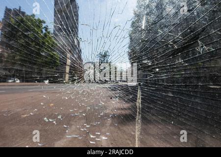 Zerbrochenes Glas im Fenster, ein Riss über dem Glas Stockfoto