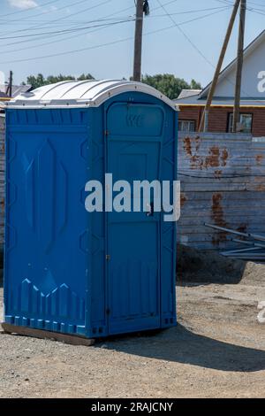 Mobile blaue Plastiktoilette auf der Straße. Individuelle Hygieneprodukte auf der Baustelle. Tragbare Toilette auf der Straße in der Stadt Stockfoto