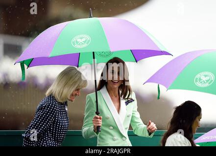 Die Prinzessin von Wales verlässt den Hof unter einem Schirm mit Deborah Jevans und Laura Robson, nachdem das Spiel zwischen Katie Boulter und Daria Saville am zweiten Tag der Wimbledon-Meisterschaft 2023 im All England Lawn Tennis and Croquet Club in Wimbledon unterbrochen wurde. Bilddatum: Dienstag, 4. Juli 2023. Stockfoto