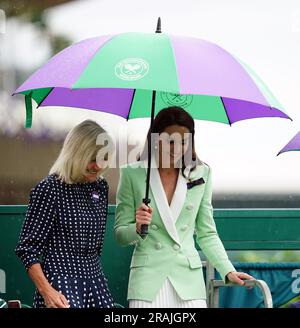 Die Prinzessin von Wales verlässt den Hof unter einem Schirm mit Deborah Jevans, nachdem der Regen im Spiel zwischen Katie Boulter und Daria Saville am zweiten Tag der Wimbledon Championships 2023 im All England Lawn Tennis and Croquet Club in Wimbledon aufgehört hat. Bilddatum: Dienstag, 4. Juli 2023. Stockfoto