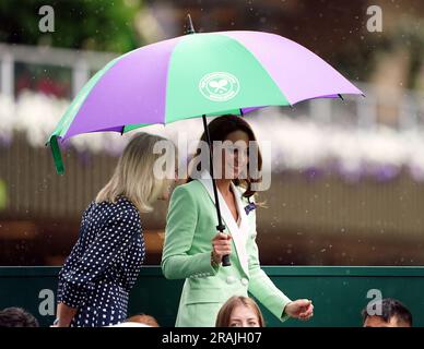 Die Prinzessin von Wales verlässt den Hof unter einem Schirm mit Deborah Jevans, nachdem der Regen im Spiel zwischen Katie Boulter und Daria Saville am zweiten Tag der Wimbledon Championships 2023 im All England Lawn Tennis and Croquet Club in Wimbledon aufgehört hat. Bilddatum: Dienstag, 4. Juli 2023. Stockfoto