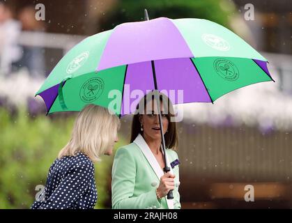 Die Prinzessin von Wales verlässt den Hof unter einem Schirm mit Deborah Jevans, nachdem der Regen im Spiel zwischen Katie Boulter und Daria Saville am zweiten Tag der Wimbledon Championships 2023 im All England Lawn Tennis and Croquet Club in Wimbledon aufgehört hat. Bilddatum: Dienstag, 4. Juli 2023. Stockfoto