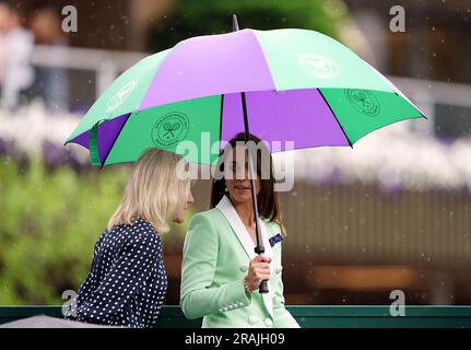 Die Prinzessin von Wales verlässt den Hof unter einem Schirm mit Deborah Jevans, nachdem der Regen im Spiel zwischen Katie Boulter und Daria Saville am zweiten Tag der Wimbledon Championships 2023 im All England Lawn Tennis and Croquet Club in Wimbledon aufgehört hat. Bilddatum: Dienstag, 4. Juli 2023. Stockfoto