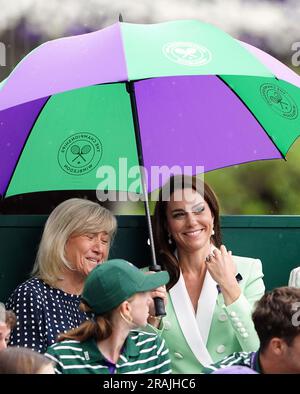 Die Prinzessin von Wales unter einem Schirm mit Deborah Jevans vor dem Regen spielt im Spiel zwischen Katie Boulter und Daria Saville am zweiten Tag der Wimbledon Championships 2023 im All England Lawn Tennis and Croquet Club in Wimbledon. Bilddatum: Dienstag, 4. Juli 2023. Stockfoto