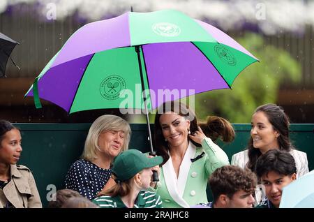 Die Prinzessin von Wales unter einem Schirm mit Deborah Jevans vor dem Regen spielt im Spiel zwischen Katie Boulter und Daria Saville am zweiten Tag der Wimbledon Championships 2023 im All England Lawn Tennis and Croquet Club in Wimbledon. Bilddatum: Dienstag, 4. Juli 2023. Stockfoto