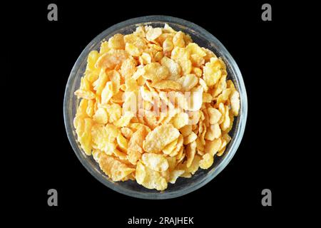 Schüssel aus Cornflakes, isoliert auf schwarzem Hintergrund Stockfoto