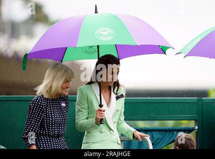 Die Prinzessin von Wales verlässt den Hof unter einem Schirm mit Deborah Jevans, nachdem der Regen im Spiel zwischen Katie Boulter und Daria Saville am zweiten Tag der Wimbledon Championships 2023 im All England Lawn Tennis and Croquet Club in Wimbledon aufgehört hat. Bilddatum: Dienstag, 4. Juli 2023. Stockfoto