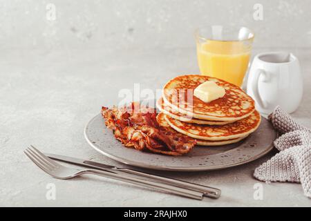 Süße Pfannkuchen mit Butter und Speck. Traditionelles amerikanisches Frühstück Stockfoto