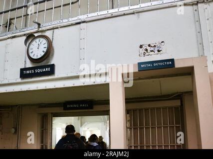 San Francisco Uhr über dem Times Square Schild neben einem Metalldetektor am Eingang zum Speisesaal Alcatraz Prison San Francisco Kalifornien USA Stockfoto